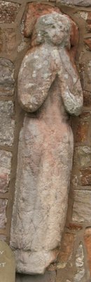All Saints Church on the exterior south wall is the 14th century stone effigy of a woman - River Eden walk, Bolton Village near Appleby, Cumbria, Northern England