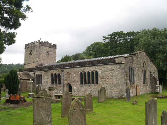 St Michael and All Angels, Hubberholme, a broad roofed low building with a sturdy tower. The building dates mainly from the late 12th century but seems to have been extended to the north in the 15th century. The porch is dated 1698 but probably a rebuild of an earlier porch.