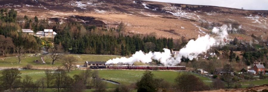 Location 08d: Winter or Summer, one of the special North Yorkshire Moors Railway steam trains running from Grosmont to Battersby, leaving Castleton Station heading westwards to Commondale. In the lower picture the River Esk is seen on the bottom left near where a mill once operated.