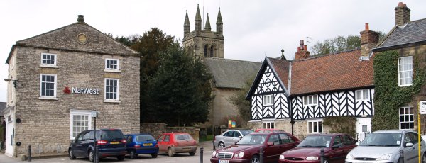 On the right, part of the Black Swan Hotel, dating back to the 15th century, which incorporates Elizabethan, Georgian and Tudor architecture, with All Saints Parish Church in the background.