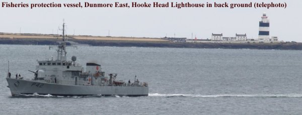 An Irish fisheries protection vessel passing Hook Head Lighthouse, viewed from above Dunmore East harbour Co. Waterford, Ireland
