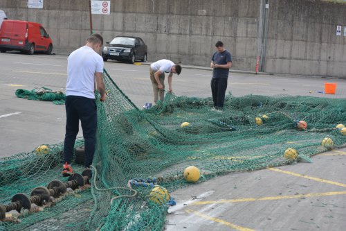 Mending the fishing nets on the quayside of Dunmore East Harbour, Waterfored, Ireland