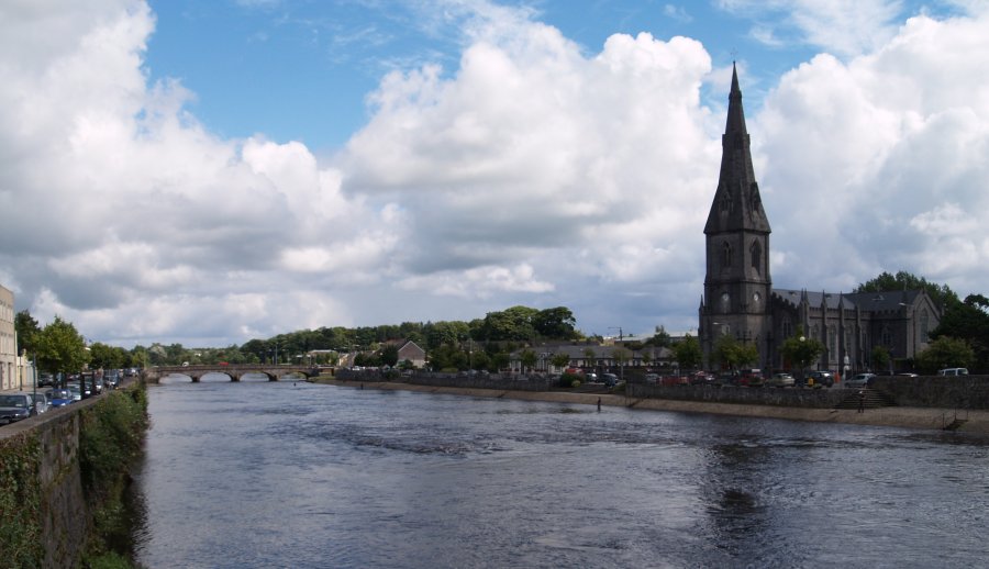 77. The tall spired church, elegant bridge and River Moy at Ballina Town, Co. Mayo. Apart from being a busy bustling town, there were lots of people fishing in the river.