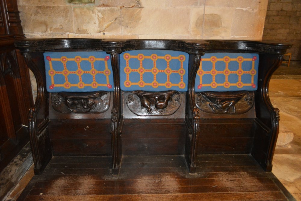 Examples of the misericord (mercy) seats in Tewkesbury Abbey Gloucestershire England
