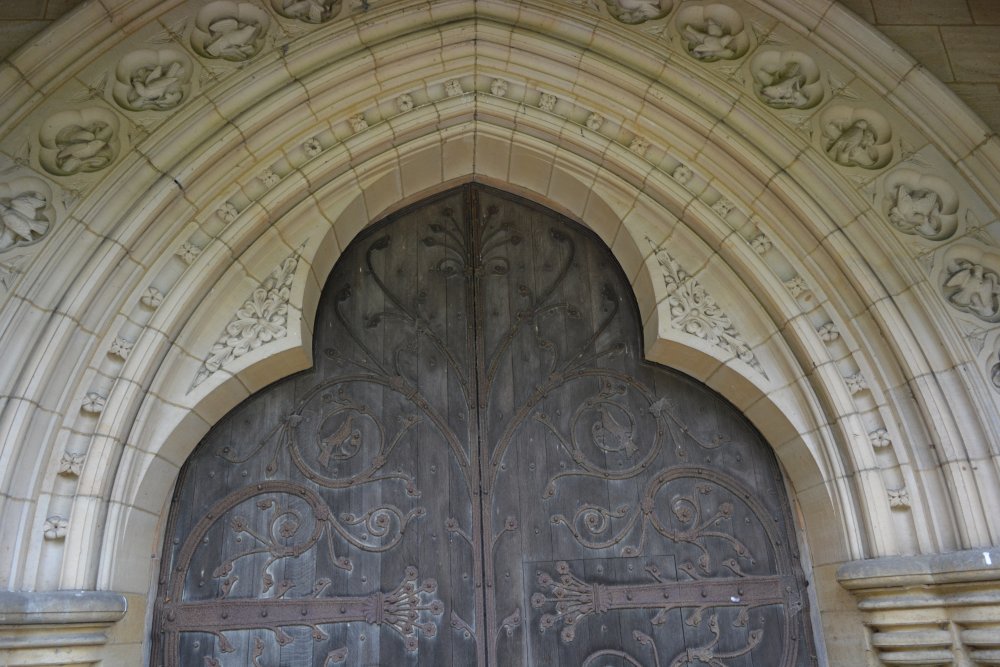 highly decorated stonework and ironwork of the west door of St Mary's Church, Studley Royal