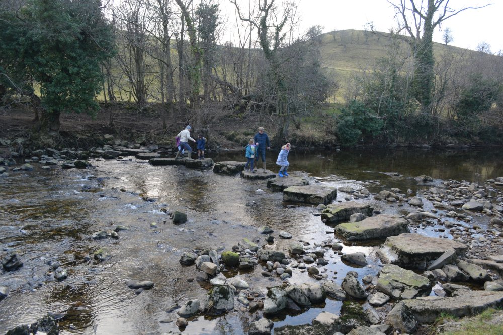 Passing by the stepping stones across the River Cover, Coverdale, North Yorkshire, England