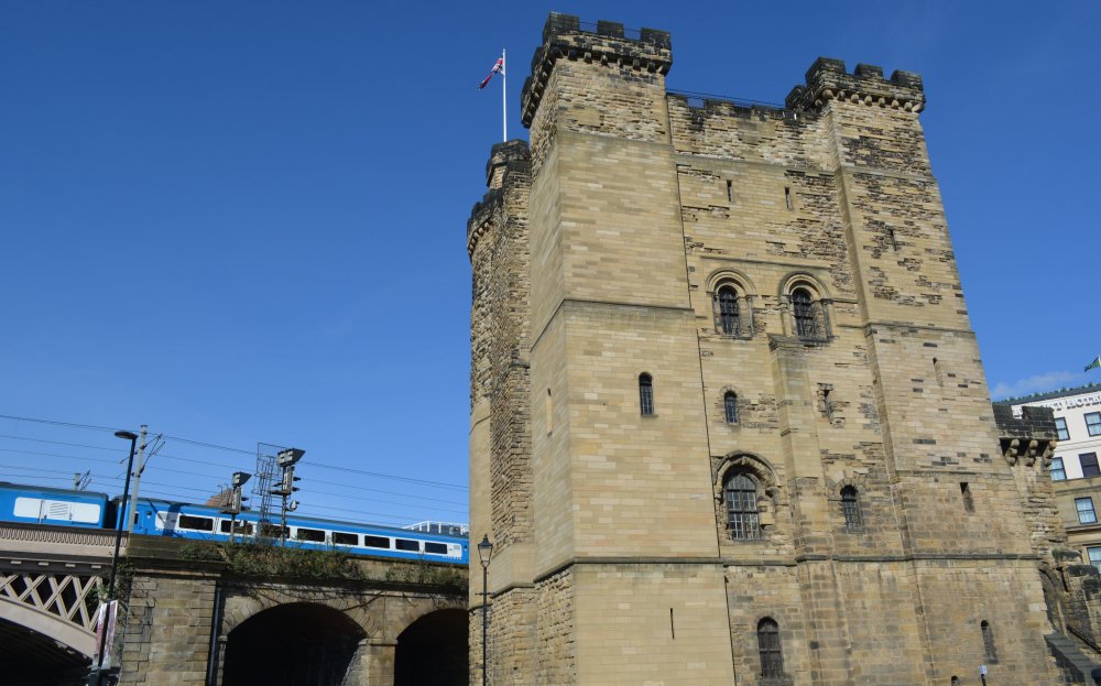 The entrance to the Newcastle Castle Keep as a Pullman train passes by, thanks to the North Eastern Railway!